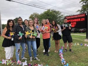TZHS artists with teacher holding Pinwheels for Peace on lawn