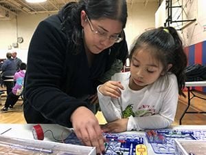 Mom helping young daughter with circuits project