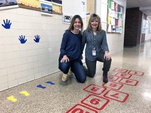 Two teachers crouching in sensory hallway