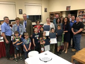 Elementary school students with teachers, administrators and Board members posed in library