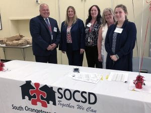 HR staffers standing by table covered with SOCSD tablecloth