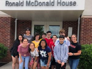 Group of students and teachers under "Ronald McDonald House" sign