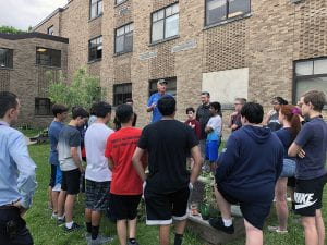 Farmer speaking with students in courtyard