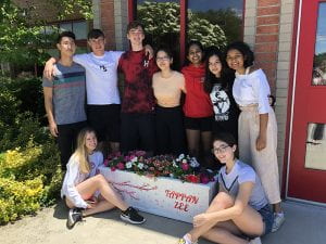 Group of students standing around painted planter they'd donated outside TZHS