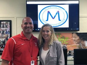 Tappan Zee High School's NYS Master Teachers Steve Cohn and Karen Connell, smiling in front of TV with NYSMTP logo