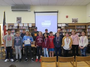 VFW members and essay contest winners posing in library