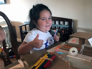 STEAM Camper gives thumbs up during cardboard construction project