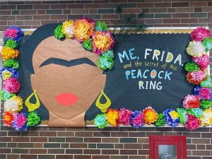 Bulletin board with "Me, Frida and the Secrety of the Peacock Ring" artwork