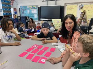 Teacher facilitating spelling activity with third graders