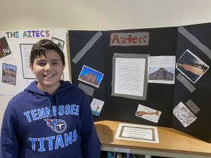 Fifth grader with poster displayed in the Blauvelt Library