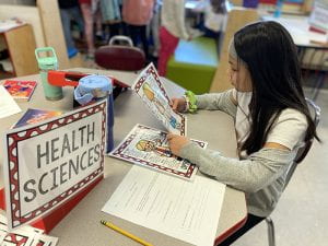 Fourth grader reads about health sciences careers