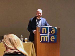 Dr. Rotjan standing behind podium with NAfME banner