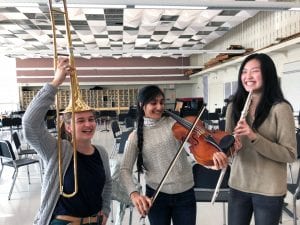 Three female musicians being silly with instruments