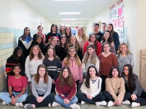 Interact Club Group Photo - students sitting, kneeling and standing in hallway